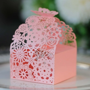 Close-up of pink laser-cut candy box featuring butterfly handle and floral lace patterns