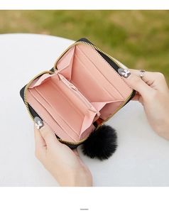 Detail view of small black faux leather wallet with pink interior and four card slots
