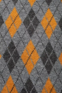 Close-up of knit fabric showing orange and grey argyle pattern with soft texture