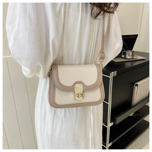 Detail view of contrast color crossbody bag with gold metal buckle and leather strap