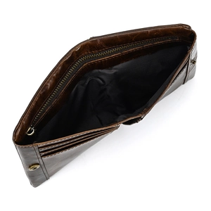 Detail of dark brown leather wallet showing the internal zipper pocket and brass snap button
