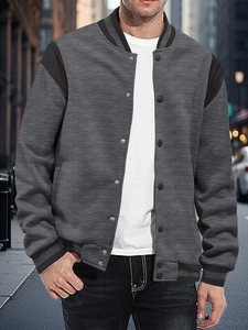 Detail of gray varsity jacket showing ribbed collar, snap buttons and color block design