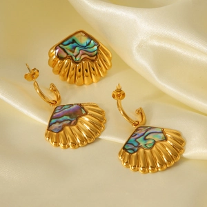 Macro detail of shell inlay jewelry set on silk background with iridescent shine