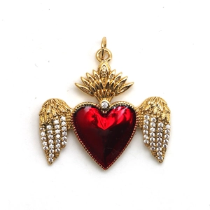 Detailed view of a gold heart pendant with red enamel, white stones, and flame motif