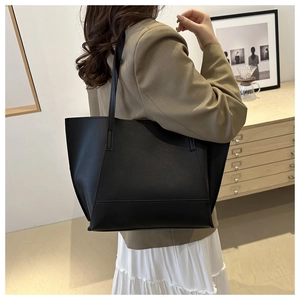 Classic matte black minimalist tote bag shown in a stylish interior lifestyle setting