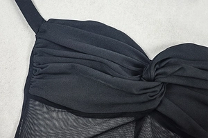 Macro shot of black chiffon pleats and central twist detail on this slim long dress
