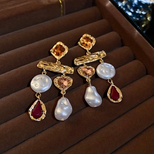 Detailed macro view of vintage gold plated earrings with pearls and amber gemstones