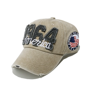 Close-up of 1964 America embroidery and American flag patch on washed denim cap