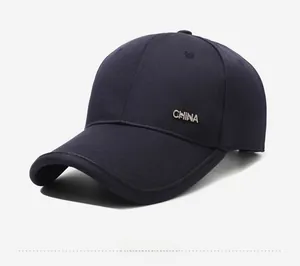 Detail of silver CHINA metal emblem on navy blue baseball cap with twill fabric texture