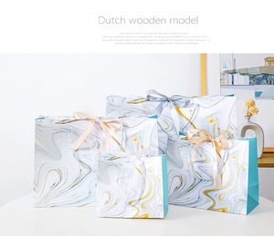 Four sizes of marble pattern paper gift bags with elegant champagne and silver silk ribbons