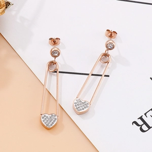 Détail de boucles d'oreilles épingle à nourrice rose doré avec pendentif cœur