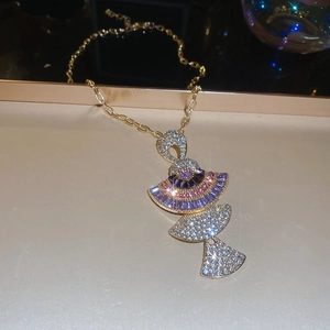 Detail of fan-shaped golden necklace with purple gems and tassel pendant design