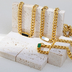 Detailed view of 18K gold plated Cuban necklaces with black, white, and green rectangle stones