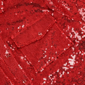 Detailed close-up of red sequin fabric texture with a flap pocket and jeweled button