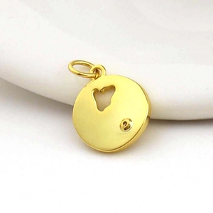 Detail of 18k gold plated hollow round charm with polished metallic finish for jewelry