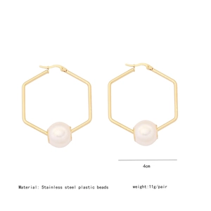 Macro view of 4cm gold stainless steel hexagonal earrings with white pearl detail