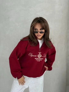 Detail of burgundy oversized sweatshirt with half-zip and British Heritage chest print