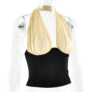 Detailed view of women's halter top with cream pleated bodice and black corset waist section