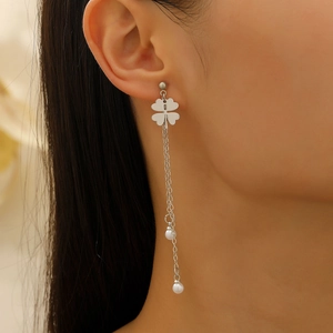 Elegant silver long tassel clover earrings with white pearls on a model's ear