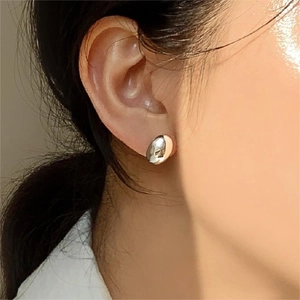 Orecchini a perno ovali in argento sterling 925 indossati per un look minimalista
