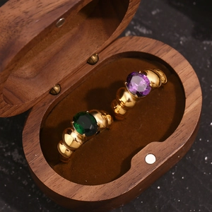 Detail of vintage 18K gold plated beaded rings with purple and green oval gemstones