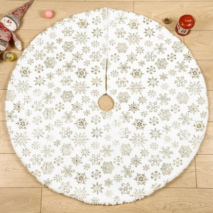 White plush Christmas tree skirt with gold snowflake patterns on wooden floor
