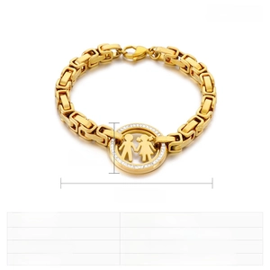 Detail of gold chain bracelet featuring a round pendant with silhouettes and rhinestones