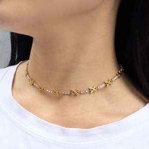 Elegant gold titanium choker featuring X-shape symbols and alternating crystal stones