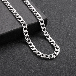 Detailed close-up of a silver polished Cuban link chain for men on a textured black box