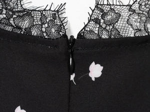 Makroaufnahme des unsichtbaren Reißverschlusses mit Spitzenbesatz am Blumenkleid