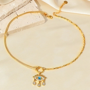 Golden evil eye necklace with blue zircon and teardrop pendants on a mixed link chain