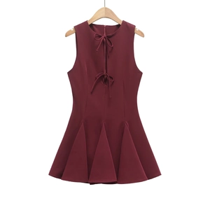 Detailed view of the dark burgundy sleeveless dress with a bow-tie neckline and pleated hem