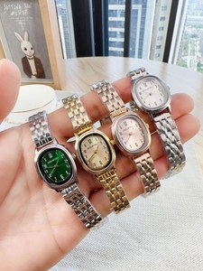 Detail view of four oval quartz watches with colorful dials and metal link bands
