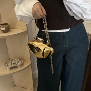 Golden mango-shaped acrylic evening bag with metallic finish and gold chain strap
