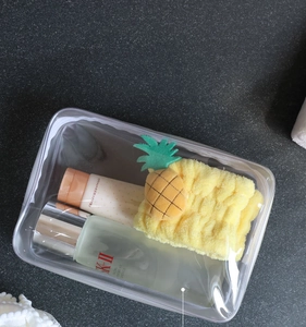 Detail of clear PVC toiletry bag showing large capacity storage with skincare items