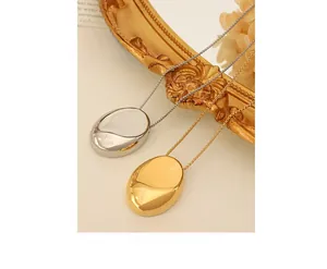 Detail of minimalist gold and silver oval pendant necklaces on vintage book pages