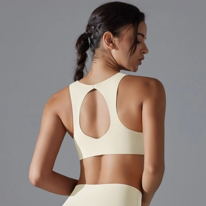 Detail view of the open circular back cutout on a beige high-stretch sports bra