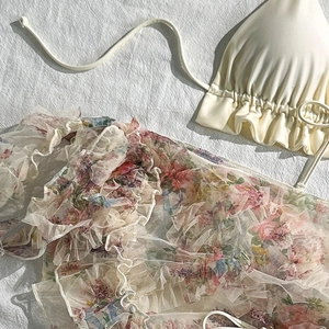 Detail of off-white ruffled bikini top with pink floral chiffon beach cover-up set