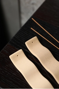 Gros plan détaillé du porte-encens en céramique ondulée avec texture mate beige sablée