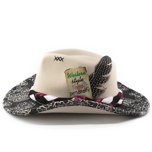 Close-up of beige wool cowboy hat with feather detail, woven band and floral brim edge