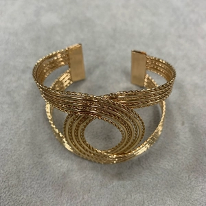 Vintage gold twisted woven cuff bracelet featuring a central concentric ring design