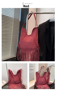 Detail of red bohemian hobo bag with sun embroidery, metal studs, and long fringes