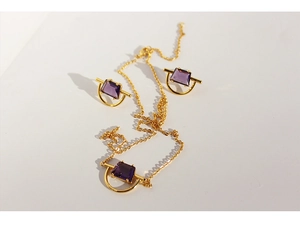 Detail of gold plated brass necklace and earrings set with purple zircon stones