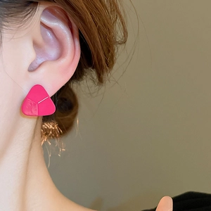 Boucles d'oreilles minimalistes triangulaires rose vif portées par un mannequin de profil