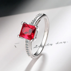 Detail of princess cut red stone ring with cubic zirconia on polished silver band