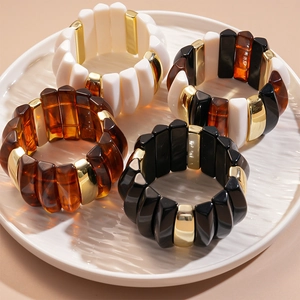 Set of four geometric acrylic stretch bracelets in white black and amber with gold spacers