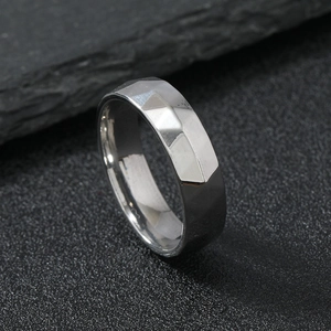 Mens silver 6mm geometric faceted stainless steel ring on a textured dark stone background