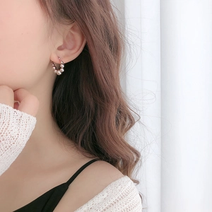 Minimalist S925 silver beaded hoop earrings worn by a model in soft natural lighting