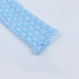 Dettaglio della manica in pizzo celeste con intricati motivi floreali traforati