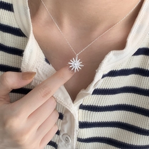 Close-up of 925 silver starburst pendant necklace featuring a central zircon stone